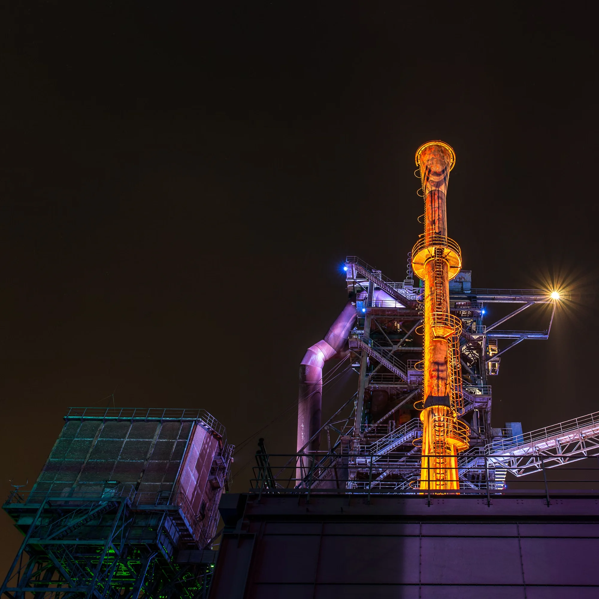 Industrial energy processing facility illuminated at twilight